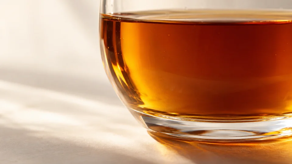 A close-up of amber syrup in a clear glass